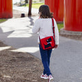 Girl walking with tween messenger bag with red and black scottie motif.