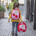 Girl carrying red and pink Dabbawalla machine washable Cherry Lunch bag and Backpack on her way home from school.