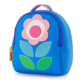 Flower Petal Backpack by Dabbawalla Bags. Modern shapes form a simple flower on the front panel of backpack. The bag is a soft blue with pink flower and shade of green leaves. Pink piping accents handle and straps.