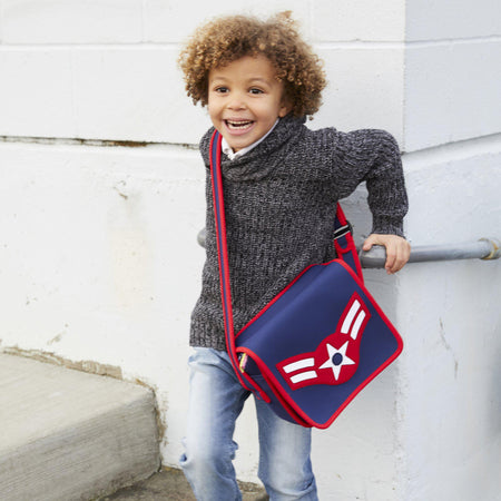 Boy wearing a red and blue American Vintage Flyer Messenger Bag  by Dabbawalla Bags.
