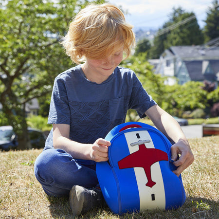 Boy using a roomy red and blue Dabbawalla lunch bag with an airplane theme.