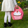 Girl carrying a cute pink Dabbawalla lunch bag.