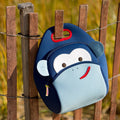 Blue Monkey lunch bag for kids and adults hanging on a wooden fence.. 