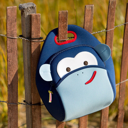 Dabbawalla Blue Monkey lunch bag hanging on a fence. 