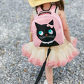 Preschool girl wearing a pink tutu kept close at hand with the Dabbawalla Bags  Miss Kitty harness bag.  Pink backpack has a cute black kitty appliqued on the front panel.